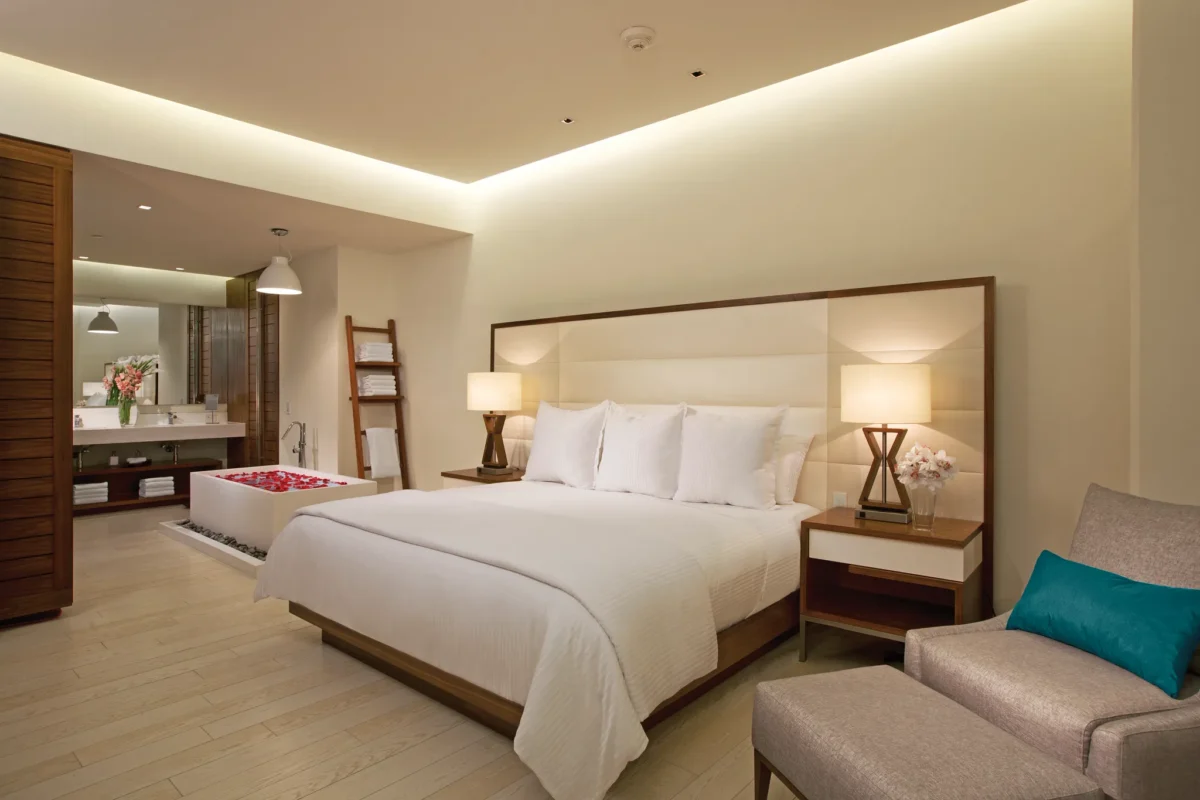 Preferred Club Governor Suite bedroom with king bed, soaking tub, and modern bathroom at Secrets The Vine Cancun.