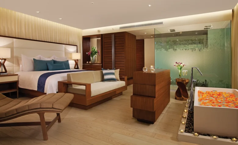 Preferred Club Honeymoon Suite Oceanfront interior with king bed, sitting area, and soaking tub at Secrets The Vine Cancun.