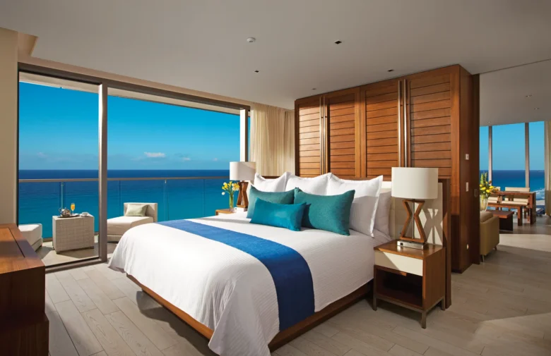 Preferred Club Master Suite Ocean Front bedroom with king bed and balcony overlooking the ocean at Secrets The Vine Cancun.