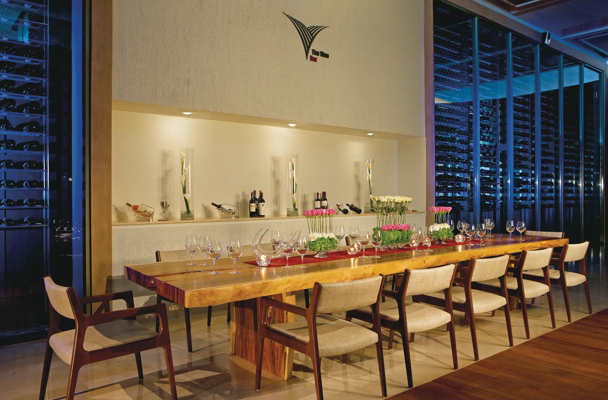 The Vine Bar wine cellar at Secrets The Vine Cancun featuring an intimate tasting room with a handcrafted wood table and premium wine selection.